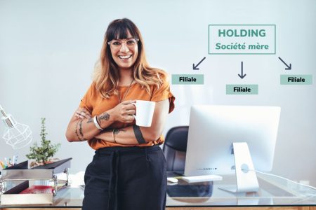 Femme entrepreneure souriante devant un schéma expliquant la structure d'un holding avec ses filiales.